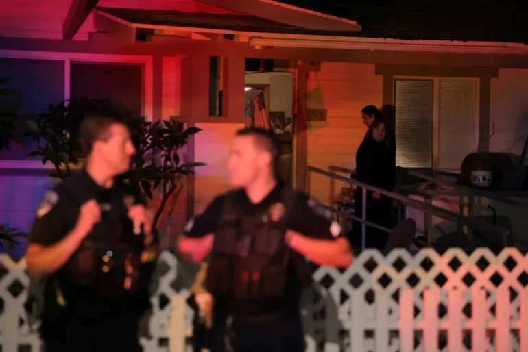 25 এপ্রিল, 2026, ক্যালিফোর্নিয়া, মার্কিন যুক্তরাষ্ট্রের টরেন্সে ওয়াশিংটন, ডিসি-তে হোয়াইট হাউস করেসপন্ডেন্টস অ্যাসোসিয়েশনের বার্ষিক ডিনারে শ্যুটিংয়ের ঘটনায় সন্দেহভাজন কোল টমাস অ্যালেনের সাথে যুক্ত বাসভবনের বাইরের কোণে পুলিশ দাঁড়িয়ে থাকা আশেপাশের লোকেরা তাকিয়ে আছে। REUTERS/Daniel Cole