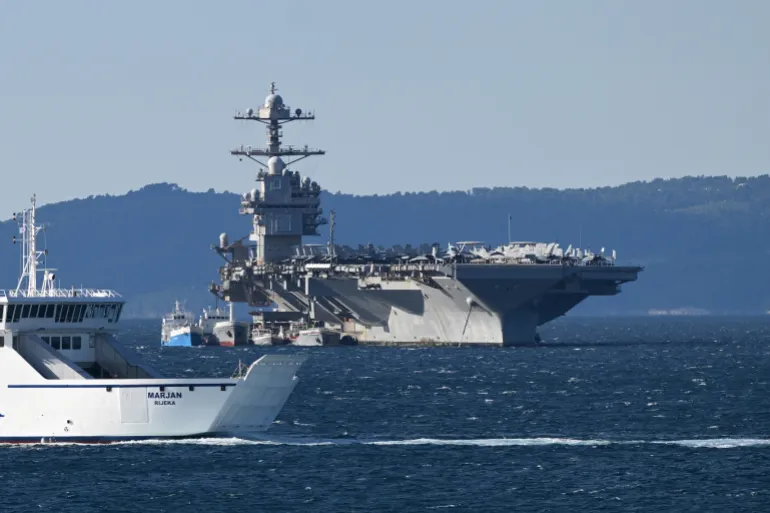 epa12858426 মার্কিন নৌবাহিনীর বিমানবাহী রণতরী USS Gerald R. Ford (CVN-78) স্প্লিট, ক্রোয়েশিয়া, 29 মার্চ 2026-এ নোঙর করে বসে আছে। লোহিত সাগরে অপারেশন চলাকালীন একটি যুদ্ধবিহীন আগুনের পর জাহাজটি মেরামতের জন্য পৌঁছেছে। বিশ্বের বৃহত্তম বাহক, যেটি সম্প্রতি অপারেশন এপিক ফিউরিকে সমর্থন করেছিল, 12 মার্চের লন্ড্রি রুমে অগ্নিকাণ্ডে তিনজন নাবিক আহত হওয়ার পরে এবং ঘুমের কোয়ার্টার ক্ষতিগ্রস্ত হওয়ার পরে ন্যাটো-মিত্র বন্দরে স্থানান্তরিত হয়েছিল। জাহাজটি মার্কিন নৌ শক্তির একটি কেন্দ্রবিন্দু হিসাবে রয়ে গেছে, যেখানে 5,000 টিরও বেশি ক্রু সদস্য এবং 75টি সামরিক বিমান রয়েছে। EPA/STRINGER